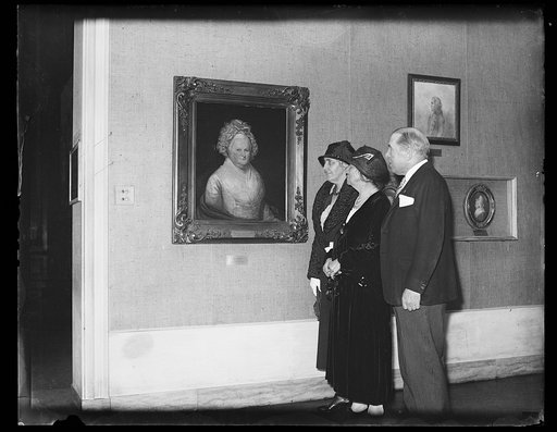 Lou Hoover and group viewing portrait in gallery