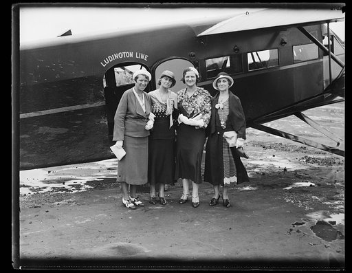 Women standing next to Ludington Line airplane