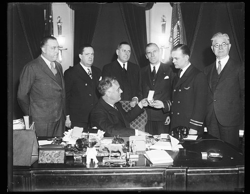 Franklin Roosevelt at desk in Oval Office with group, Washington, D.C.