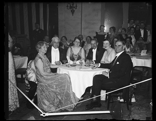 Men and women at table; George Dern, right