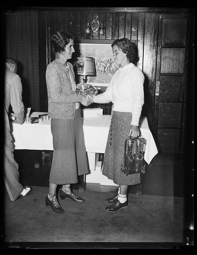 WINS MIDDLE ATLANTIC GOLF TITLE FOR WOMEN. This photograph shows the awarding of the prize to the new Middle Atlantic golf champion, Mrs. David H. Clark, Army & Navy Club of Washington. From the left Mrs. Clark, Miss Lily Harper, 19-year-old Portsmouth, Va., runner-up, and Charles H. Doing, Jr., pre