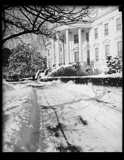 White House view. 1/23/35. Winter decorates White House. Snow and frozen rain combine to give an unusual touch to the pathway leading to the executive wing of the White House on the south side. 1/24/35