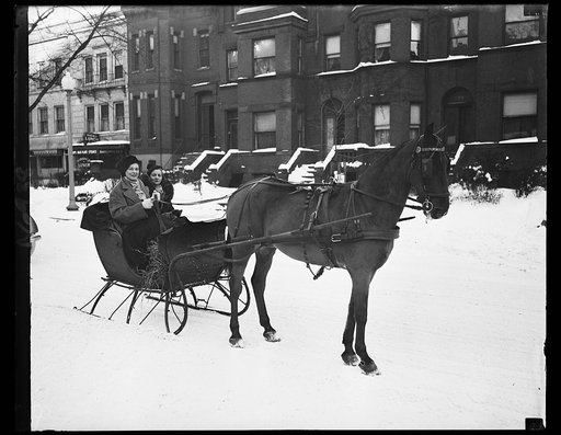 Socialites enjoy winter. These two prominent members of Washington's social set enjoy the clear, cold aftermath of the blizzard which left the streets covered with nearly a foot of snow. Miss Evelyn Walker, daughter of Mr. and Mrs. Harold Walker, is wearing the Russian-type hat. Her companion is Mrs