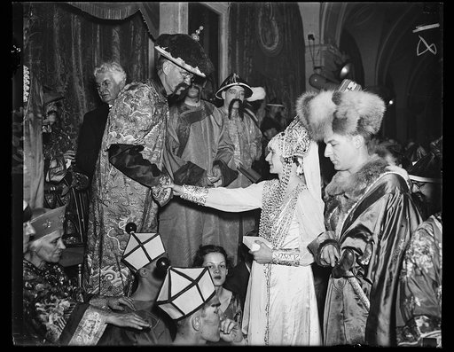 Bal Boheme winner. Mr. and Mrs. Melville Grosvenor of Washington drew upon the resources of a king to capture first prize at the Bal Boheme, a social event of gaiety and costume held annually. Judge Charles Bittinger, President of the Arts club, is making the award. Mr. Grosvenor, the son of Mr. and