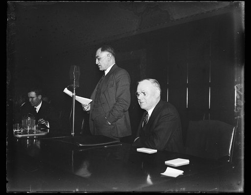 Twenty-two million workers concerned as Green listens. A.C. Wharton, president of the International Association of Machinists, left, addresses the NRA hearing on code employment provisions. William Green, president of the A.F. of L. listens. The NRA hearing was held to guide the administration in th