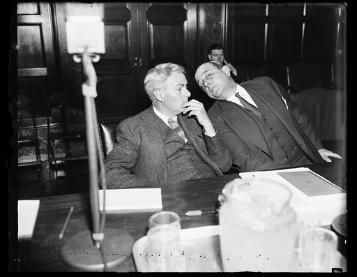 Holds hours and wage hearings in NRA. Walton H. Hamilton, left, of the NRA board, and S. Clay Williams, Chairman of the Board, preside at the open hearing by which the NRA expects to receive guidance on labor provisions of codes in the event the recovery organization is continued by Congress. 1/30/3