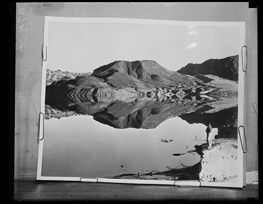 Landscape with man viewing mountain reflection in lake
