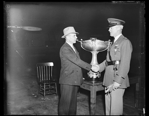 Major James H. Doolittle (left), vice president of the National Aeronautic Association, congratulates Brigadier General Henry H. Arnold for his receipt of the Mackay Trophy (in background)