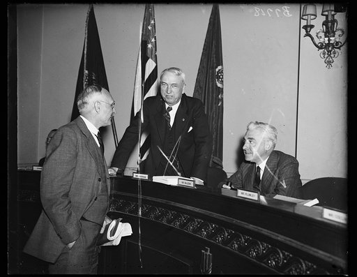 Three men near seat name tags: Mr. Andrews, Mr. McClain, Mr. Plumley