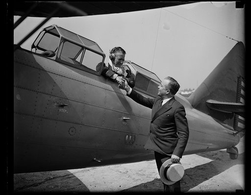 Pilot shaking hand with unidentified man from airplane