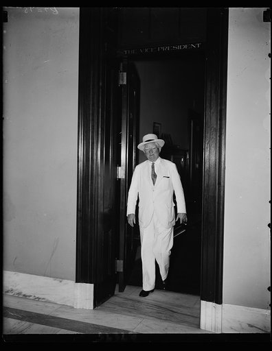 Set for summer. Vice President John Nance Garner emerging from his air conditioned office to face the annual summer heat wave at the Capitol decked out in Washington's regulation summer regalia. 6/24/35