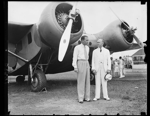 Before he clipped a wing [...] Aviator Clyde Pangborn, world famous flyer, photoed at Wash., D.C., with Asst. Sec. of War, Harry Woodring, just a few moments before the ship, in taxing down the runway, clipped wings with another plane on the field as Fangborn prepared to given Congressmen and notabl