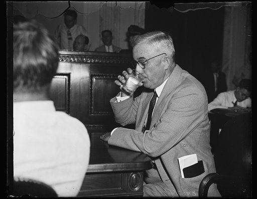$8,000,000 "not improper." John W. Carpenter, Dallas, Tex., Pres. of Texas Power & Light, pauses amidst a hot Senate lobby inquiry Wednesday for a nip of ice water. Carpenter, in his testimony, admitted he did not think it "improper" when the Texas company's common stock was "written-up" from $2,390