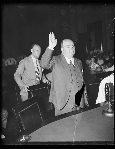 Keep your foot off my chair. Howard C. Hopson, reputed Association Gas & Electric Co. Boss, is the subject of intense questioning when brought before the House lobby investigation committee after many days of search. 8/13/35