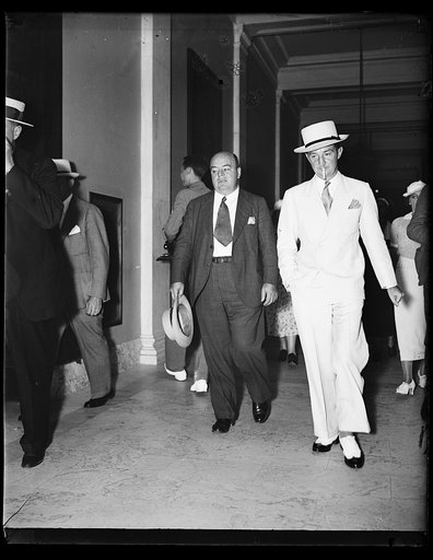 Back in lobby limelight. Howard C. Hopson, Associated Gas & Electric king pin in the Senate lobby quiz, and an associated, Bernard B. Robinson (the tall one) photographed in the corridors of the Senate office building following a strenuous session with the Senate committee. 8/22/35