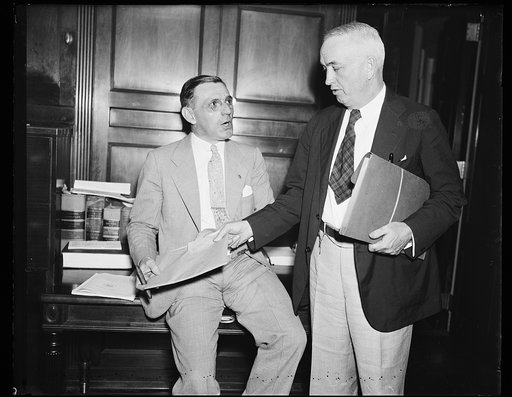 Principals at Friday hearing [...] Rep. John J. McSwain (D. of S.C.), chairman of the House Military Com. and the key witness at the Friday hearing, Frank E. Speicher whose testimony created a sensation on "deals" with the army. McSwain is standing. 7/26/35
