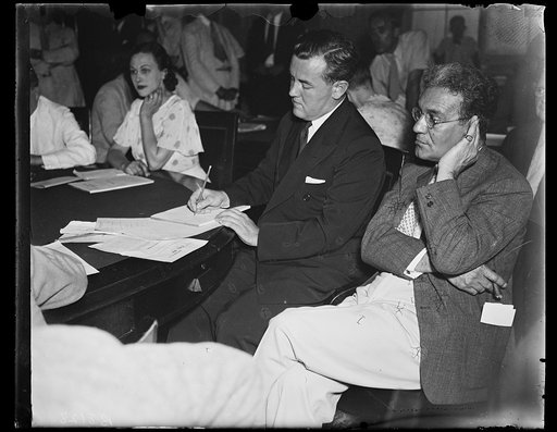 Waits his turn [...] Thomas Cocoran, RFC Atty., who is being connected with Lobby charges at a special House rules investigation, left, listens in while Rep. Ralph Brewster (R. of Maine) accuses him of using [passamaquoddy?] "pressure" threats to get his coat for the Utility bill. Judge Ferdinand Pe