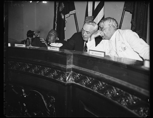 "Conspiracy" hinted. Wash. D.C. Rep. John J. McSwain (D. of S.C.) chr. of the House Military Affairs Com., left, hears testimony at the Friday inquiry about "cash passing." W. Frank James, Chief Investigator of Military Affairs, right, is also an interested party at the hearing. McSwain observed tha