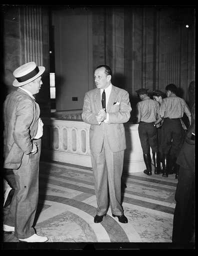 Somebody else is getting it. Wash. D.C. B. Shearer, munition lobbyist supreme, seems to be enjoying proceedings at the Senate Commerce Committee where Ewing Y. Mitchell, ousted Commerce Department official, is "revealing all" in his graft charges. Earlier in the session, Shearer occupied a "hot seat