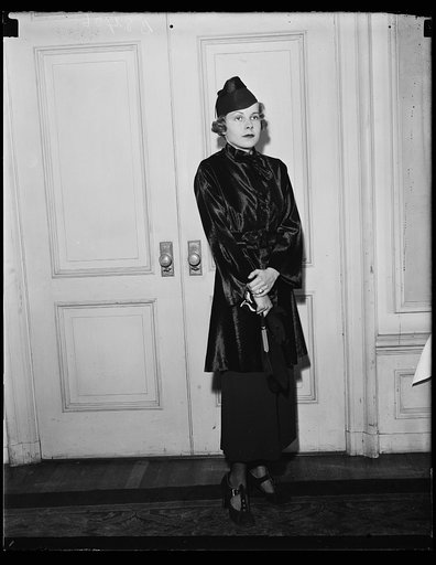 Cocktail dress. Miss Polly Wayne Wirgman modeling a cocktail dress of seal with a high neck and a three quarter jacket. The style show was sponsored by the Dorothy Hancock Chapter of the Daughters of the American Revolution and was held at the Raleigh Hotel. 10/23/35