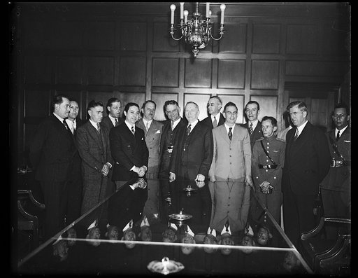 Secretary Daniel C. Roper, (dark suit and standing at the center of the table) receives a delegation of Latin American flyers and aviation leaders at the Commerce Department. Secretary Henry Wallace, extreme right, also met the delegation. 10/14/35