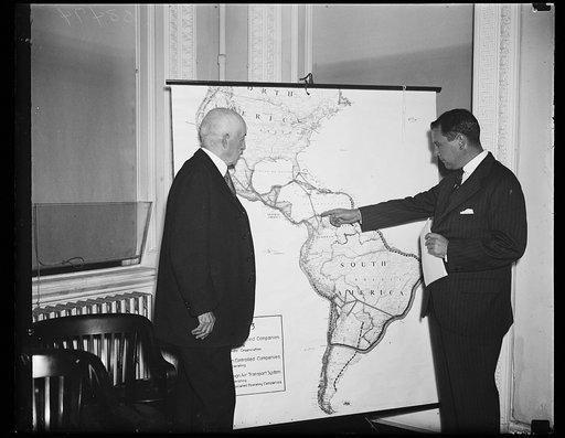International Air Path Conference. R. Walton Moore, Assistant Secretary of State, left, and Juan T. Trippe, President of Pan-American Airways, studying International routes for airplanes. A meeting was held to recommend methods of promoting and preserving American interests in international air lane
