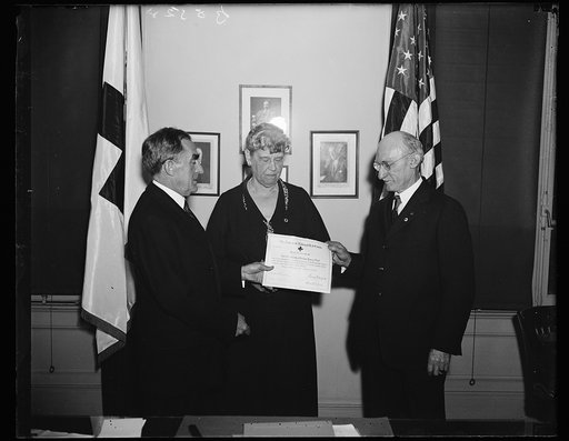 Receives millionth Red Cross award right. William Henry Nutt, of Perth Amboy, N.J. receives from Admiral Cary T. Grayson, chairman of the Red Cross, a certificate showing that he is one millionth man to take the Red Cross First Aid course. Miss Mabel T. Boardman, an officer of the Red Cross, also is