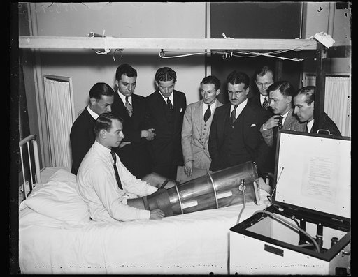 Pumping bot examined. Students at Georgetown University Hospital gather around Chester Antos, another student, while they examine a newly devised Emerson suction pressure apparatus used to stimulate circulation in legs and feet when certain diseases threaten to neccessitate amputations. The "boot", 