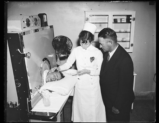 Fever machine used to kill germs, Wash. D.C. Bennie Smith, an arthritis patient, receives treatment at Gallinger Municipal Hospital in the fever machine used to raise temperatures artificially. With his temperature at 105 he grins and asks for more ice. Nurse-technician Ida Louise Rivers is counting