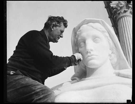 Wash. D.C. Chiseling on justice. Gino A. Ratti, carver, puts the finishing touches on "Contemplation of Justice," installed at the entrance of the new U.S. Supreme Court building. J.E. Frasier is the sculptor. 11/22