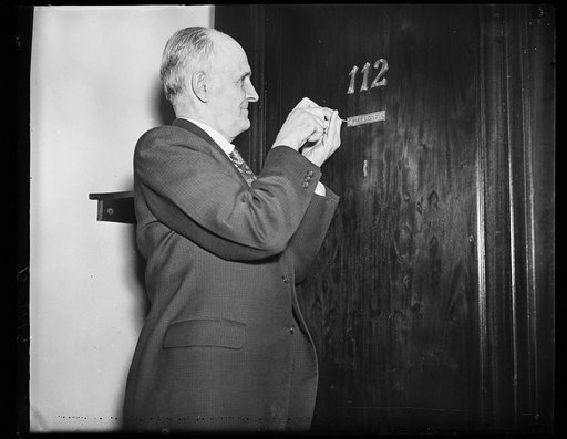 Man putting name plate on door: "Mrs. Long"
