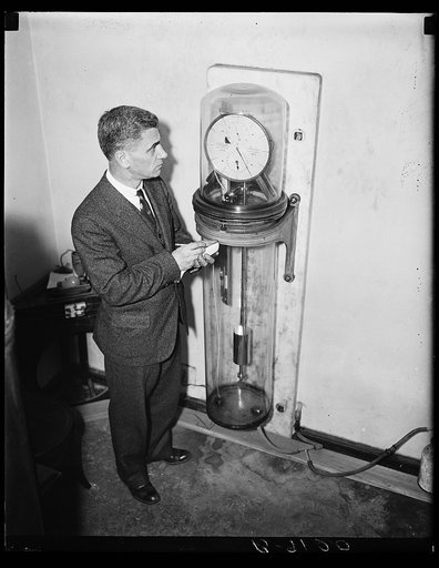 Man with a Riefler pendulum clock, the primary standard for time interval measurements from 1904 to 1929