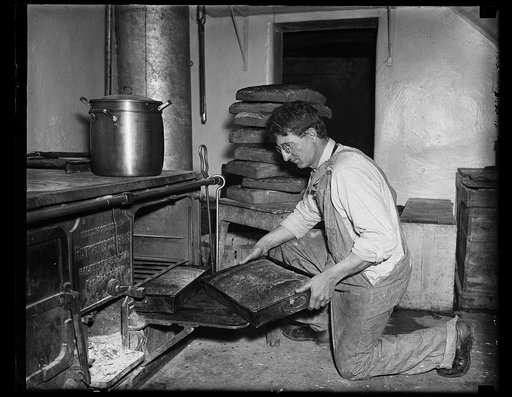 Man removing pan with bread? from oven