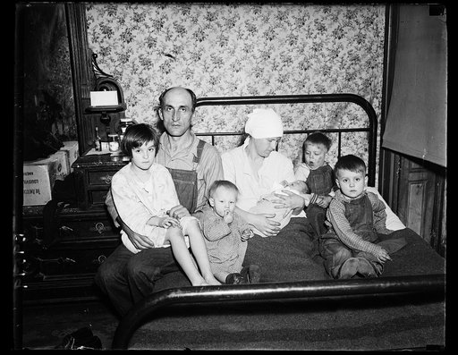 Family with 5 children, seated on bed