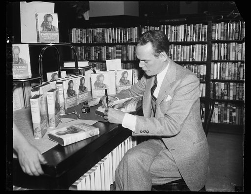 Erskine Caldwell signing copies of book "Tobacco Road"