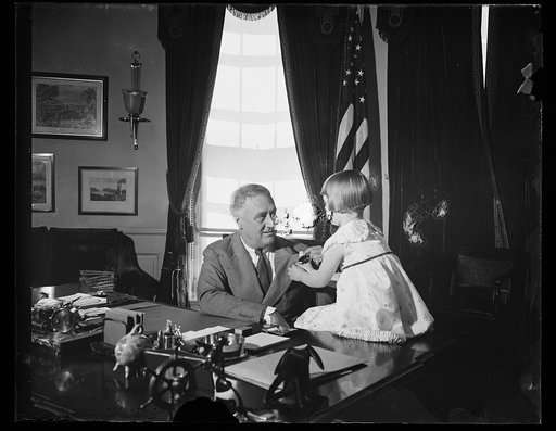 Franklin Roosevelt at desk with child