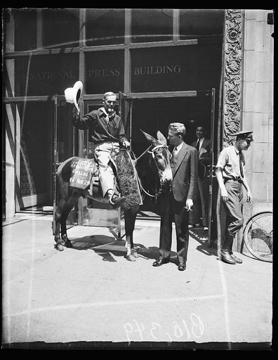 Man on donkey ("Texas Centennial Exposition, Dallas, Nov. 29") in front of National Press Building, Washington, D.C.