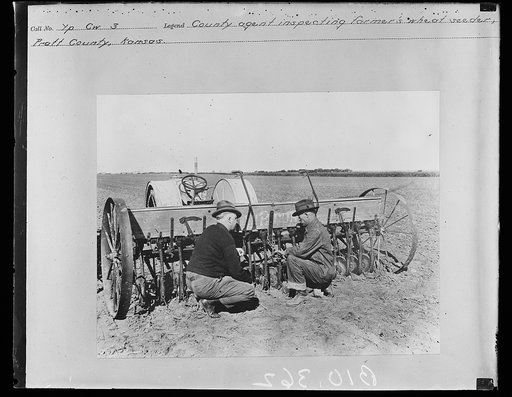 County agent inspecting farmer's wheat seeder, Pratt County, Kansas