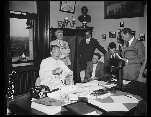 Burton K. Wheeler at desk; with group