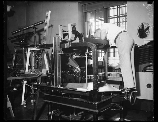 Taking out kinks. Washington, DC. June 29 --T.W. McKinley, printing expert of the Coast & Geodetic Survey, is testing the new printing camera devised to handle negatives made by the new nine-lens aerial camera. The printing camera lens is designed to compensate for distortion caused by the angles of