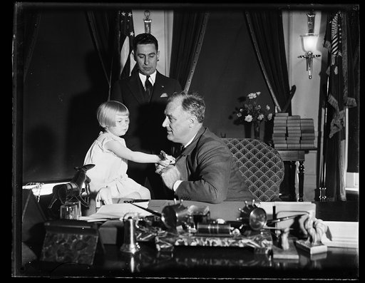 CHIEF EXECUTIVE RECEIVES FIRST 'BUDDY' POPPY. LITTLE MURIEL MORGAN CAME FROM THE VETERANS OF FOREIGN WARS HOME FOR WIDOWS AND ORPHANS OF EX-SERVICES MEN IN FATON RAPIDS, MICHIGAN, TO PRESENT PRESIDENT ROOSEVELT WITH THE FIRST BUDDY POPPY TO OFFICIALLY OPEN THE 1934 NATIONAL POPPY SALE CONDUCTED BY T