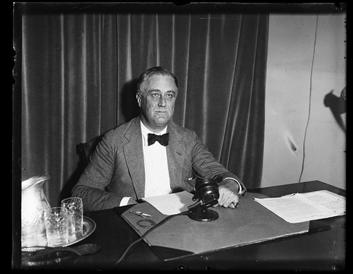 CHIEF ASKS PEOPLE TO JUDGE RECOVERY PROGRAM. PRESIDENT ROOSEVELT, AS HE PREPARED TO ADDRESS THE NATION OVER THE RADIO, CALLS UPON THE PEOPLE TO JUDGE THE MERIT OF THE RECOVERY PROGRAM. THE RADIO ADDRESS WAS MADE JUST BEFORE THE PRESIDENT LEFT ON HIS SUMMER VACATION. NOTICE THE BLACK BOW WORN BY THE 