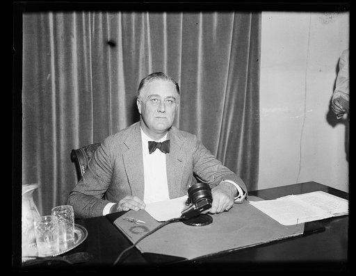CHIEF ASKS PEOPLE TO JUDGE RECOVERY PROGRAM. PRESIDENT ROOSEVELT, AS HE PREPARED TO ADDRESS THE NATION OVER THE RADIO, CALLS UPON THE PEOPLE TO JUDGE THE MERIT OF THE RECOVERY PROGRAM. THE RADIO ADDRESS WAS MADE JUST BEFORE THE PRESIDENT LEFT ON HIS SUMMER VACATION. NOTICE THE BLACK BOW WORN BY THE 