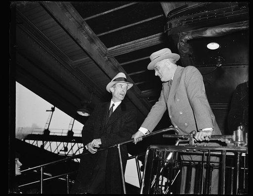 LAST MINUTE INSTRUCTIONS TO HIS SECRETARY. President Roosevelt has a few words to say to his secretary. Marvin McIntyre, left, just before the Presidential special train left Washington for the south. The president said he wore a light suit "because I'm heading south"