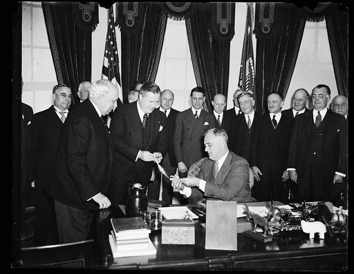 PRESIDENT RECEIVES PAN AMERICAN AWARD. SPRUILLE BRANDEN, MEMBER OF THE COUNCIL OF THE PAN AMERICAN SOCIETY, MAKES THE PRESENTATION OF THE SOCIETY'S AWARD TO PRESIDENT ROOSEVELT. THE AWARD WAS MADE FOR THE PRESIDENT'S 'GOOD NEIGHBOR' POLICY PROMOTING FRIENDSHIP BETWEEN THE NATIONS OF NORTH AND SOUTH 