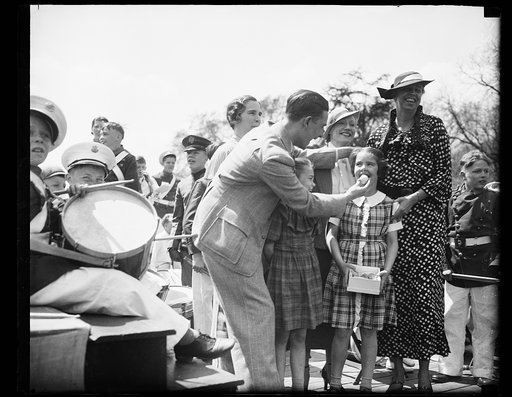 SURPRISED? MAGICIAN CHRISTOPHER, LEFT, EXTRACTS AN EGG, SO IT SEEMS, FROM THE MOUTH OF SURPRISED DIANA ROOSEVELT, DAUGHTER OF MRS. J. HALL ROOSEVELT OF DETROIT, AT THE ANNUAL EASTER EGG ROLLING AT THE WHITE HOUSE. MRS. FRANKLIN ROOSEVELT IS SHOWN AS SHE GREETED THE THOUSANDS OF WASHINGTON YOUNGSTERS