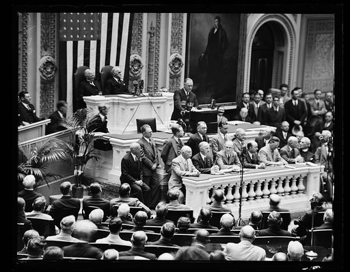 MAKING SOME HISTORY. PRESIDENT ROOSEVELT, STANDING ON THE ROSTRUM OF THE HOUSE CHAMBER, MAKES A BIT OF HISTORY BY APPEARING BEFORE A JOINT SESSION OF CONGRESS TO DELIVER A VETO OF THE PATMAN BONUS BILL. THIS IS THE FIRST TIME SUCH ACTION WAS TAKEN BY A PRESIDENT, AND MARKS A NEW HIGH FOR PRESIDENTIA
