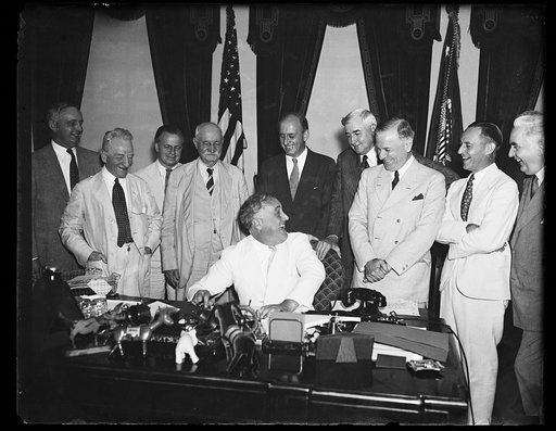 A FUNNY BUSINESS. THE BUSINESS OF GETTING THE PRESIDENTIAL SIGNATURE ON THE ADMINISTRATION'S BANKING BILL TOOK ON A JOCULAR TONE AS PRESIDENT ROOSEVELT, SEATED, JOKES WITH REP. HENRY STEAGALL, (D-AL), WHO HANDLED THE HEARINGS IN HIS HOUSE BANKING AND CURRENCY COMMITTEE. FROM THE LEFT: SEN. CARTER GL