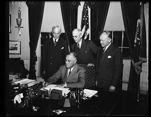 ROOSEVELT SIGNS PHILIPPINE COMMONWEALTH PROCLAMATION. PRESIDENT ROOSEVELT SIGNS THE PROCLAMATION TERMINATING THE EXISTING GOVERNMENT OF THE PHILIPPINES AND ESTABLISHING THE COMMONWEALTH UNDER A CONSTITUTIONAL FORM OF GOVERNMENT. HE ALSO WISHED THE PHILIPPINO PEOPLE GOOD LUCK. FROM THE LEFT: SECRETAR