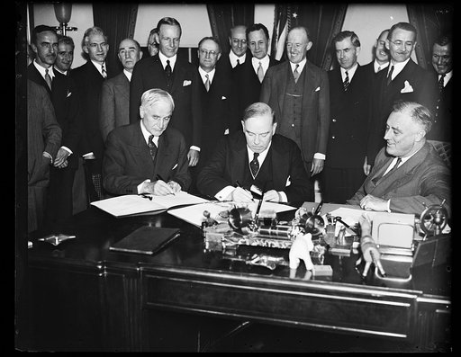 CANADIAN TRADE PACT SIGNED. ADMINISTRATION OFFICIALS RALLIED IN THE EXECUTIVE OFFICE OF THE WHITE HOUSE TO WATCH PRIME MINISTER WILLIAM MacKENZIE KING OF CANADA AND SECRETARY OF STATE CORDELL HULL SIGN THE RECIPROCAL TRADE TREATY DESIGNED TO STRENGTHEN FRIENDSHIP AND ECONOMIC RELATIONS BETWEEN UNITE